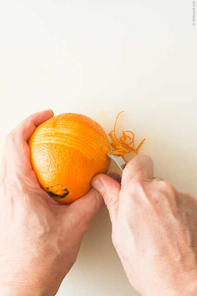 Zesten aus Orangenschale reißen mit dem Zestenreißer