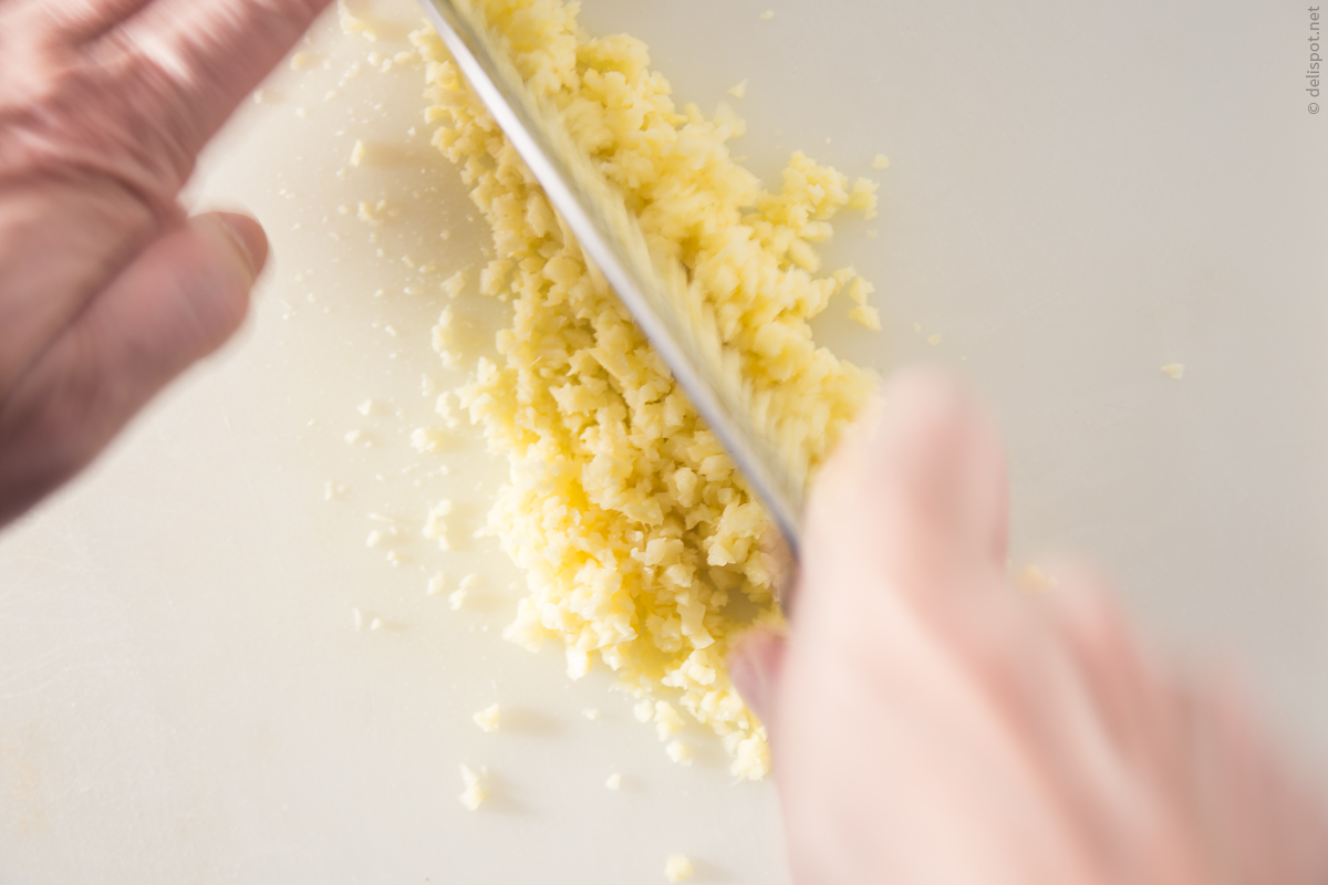 Ingwer (Zingiber officinale) wird mit dem Messer gehackt