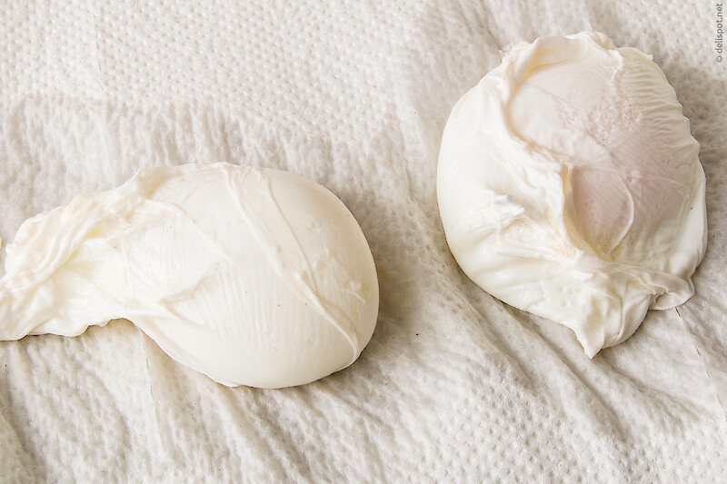 Zwei pochierte bzw. verlorene Eier tropfen auf Küchenpapier ab