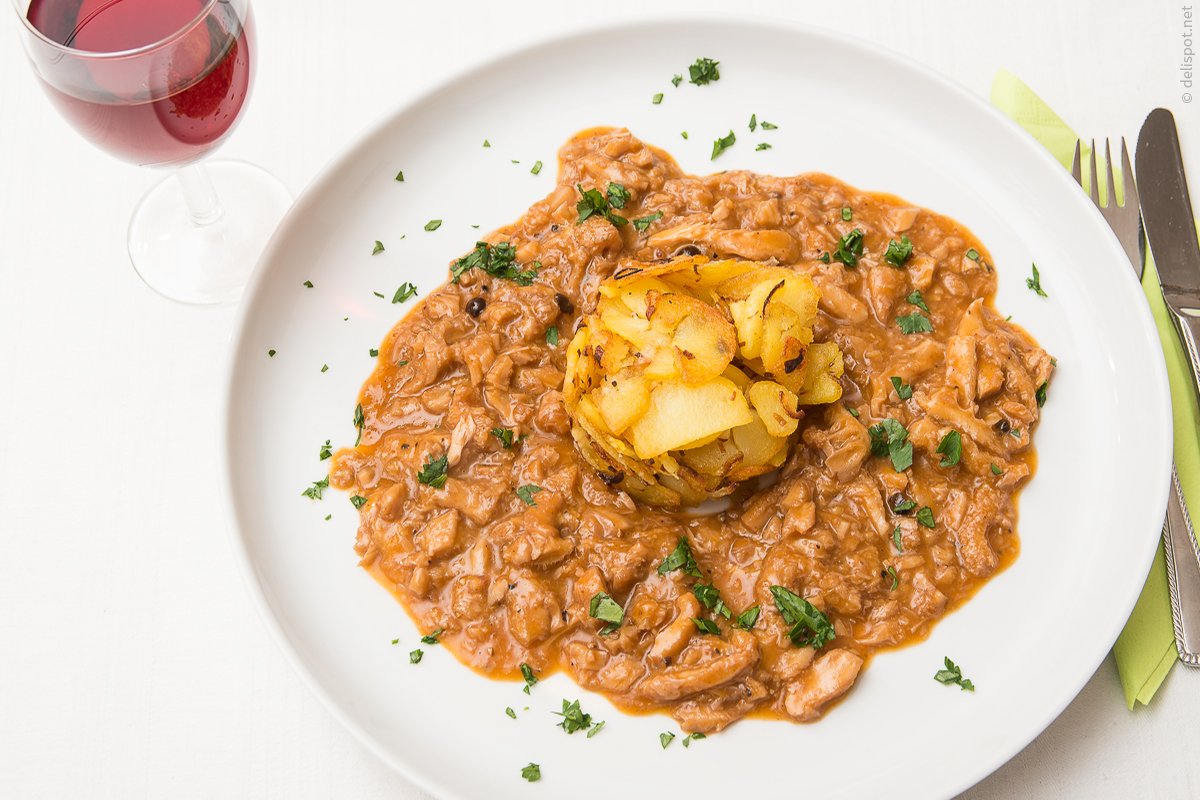 Saure Kutteln, angerichtet mit Bratkartoffeln, dazu ein Glas Trollinger