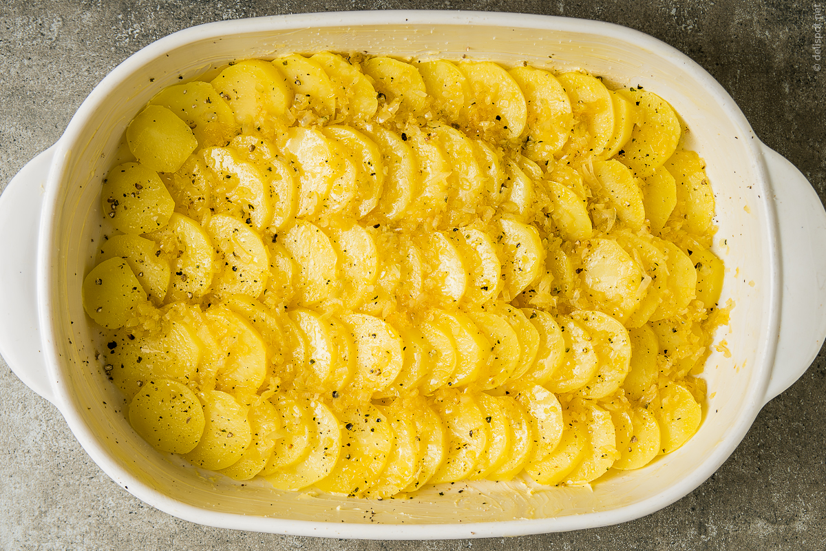 Munster chaud – gedünstete Zwiebelwürfel auf den Kartoffelscheiben verteilen
