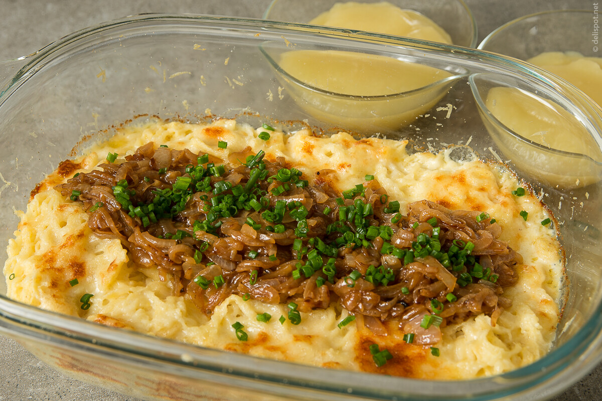 Käsespätzle, angerichtet mit Schmelzzwiebeln und Schnittlauch-Röllchen, als Beilage Apfelmus