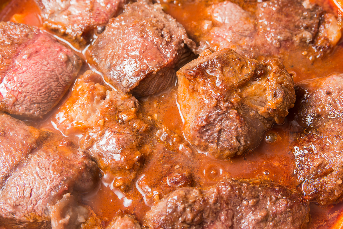 Bœuf bourguignon, angebratene Fleischstücke werden mit Rotwein übergossen