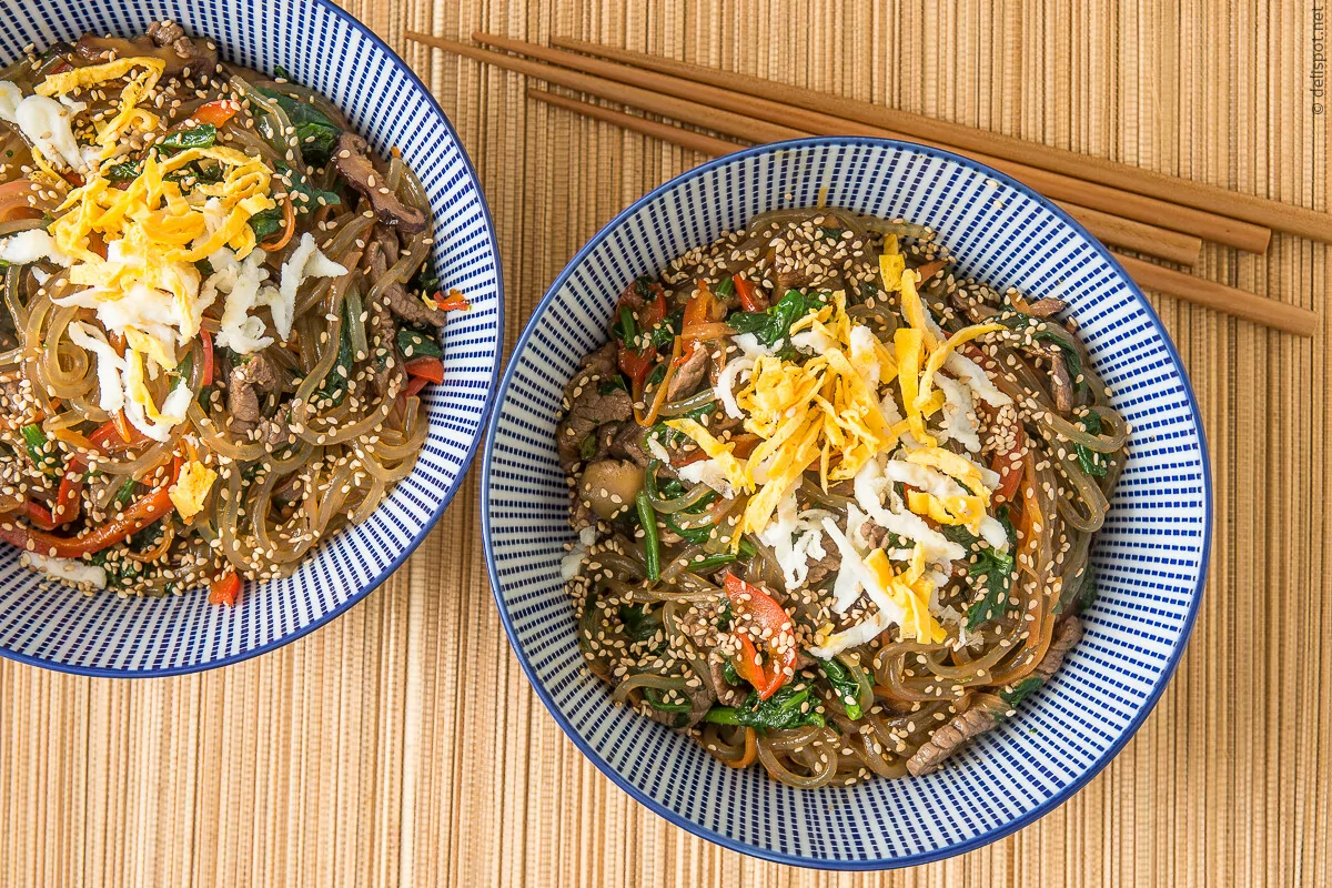 Japchae, koreanisches Nudelgericht, angerichtet in zwei Schalen