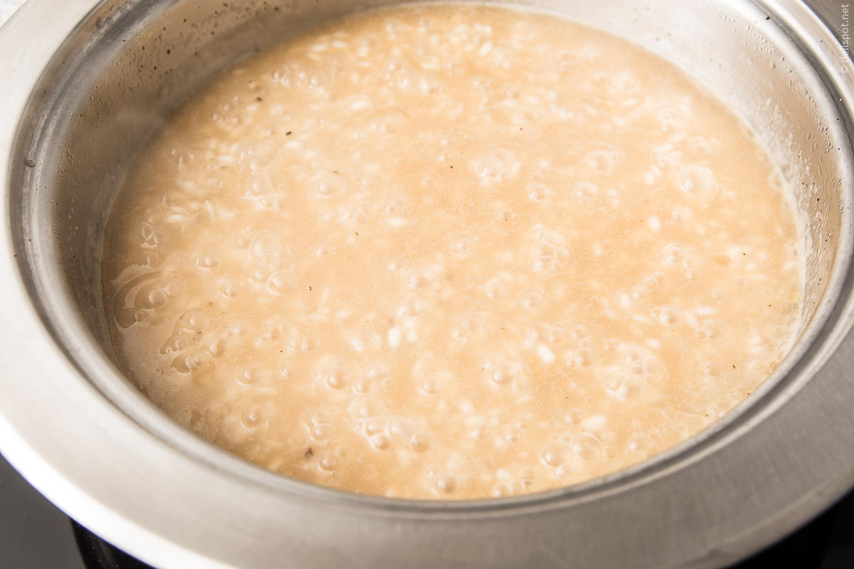 Risotto-Zubereitung: Angedünstete Zwiebeln und Reis werden mit Weißwein abgelöscht und mit Brühe übergossen