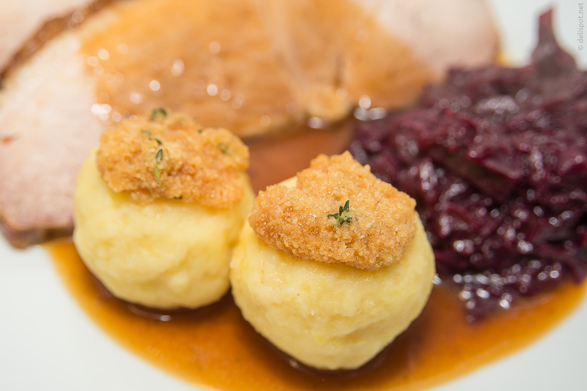 Kartoffelknödel mit Butterbröseln als Begleiter zu Schweinebraten und Rotkohl angerichtet