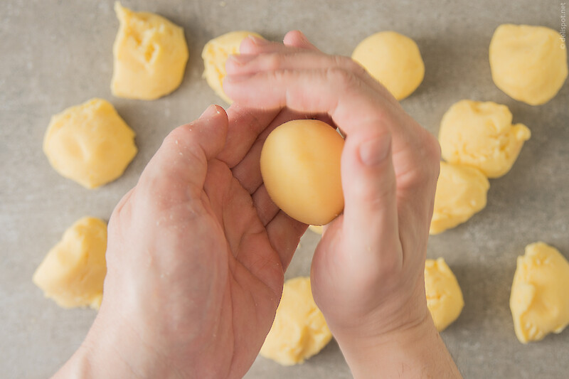 Knödelmasse portionieren und mit beiden Händen Klöße abdrehen