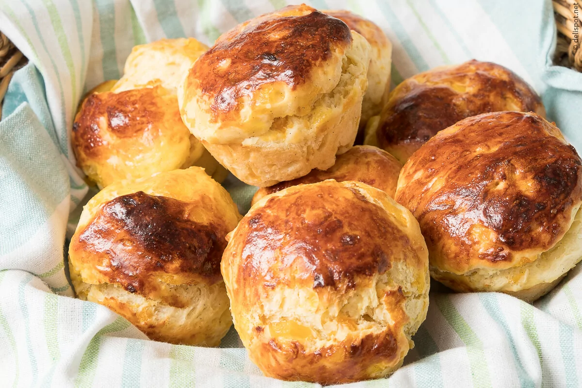 Brioche, runde Einzelstücke, frisch gebacken im Brotkorb, eingeschlagen in ein Tuch
