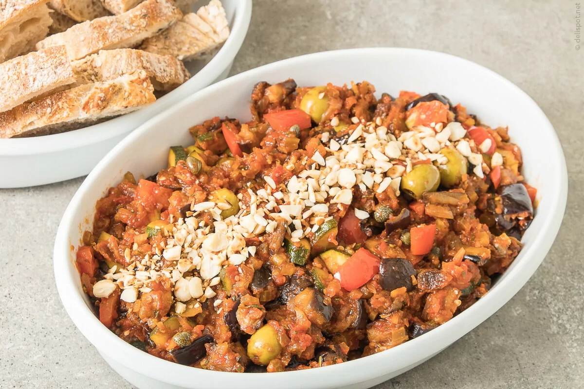 Caponata siciliana, angerichtet In Schale und mit gerösteten Mandeln bestreut
