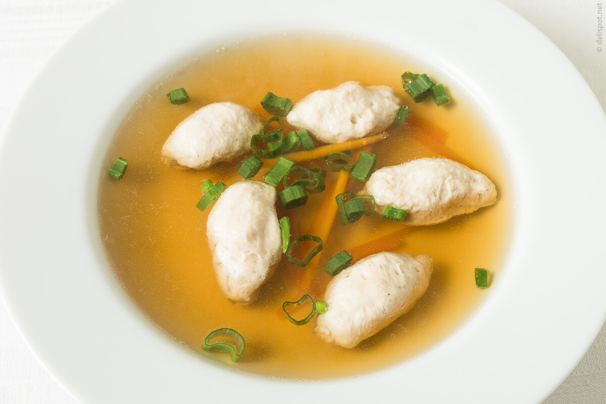 Bouillon mit Brätklößchen, in Teller angerichtet und mit Frühlingszwiebeln bestreut