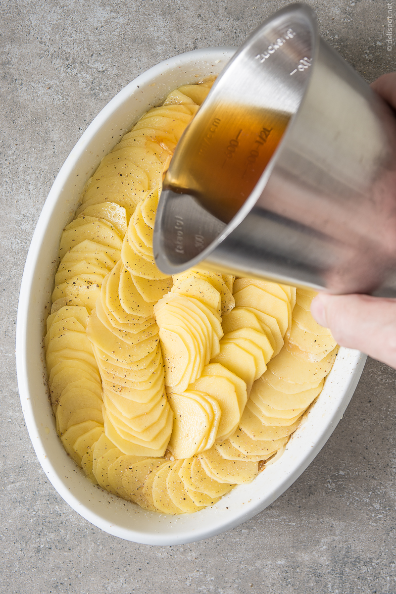 Herstellung Bäckerinkartoffeln (Pommes boulangère), Schritt 3: Die Kartoffeln werden mit Fond begossen