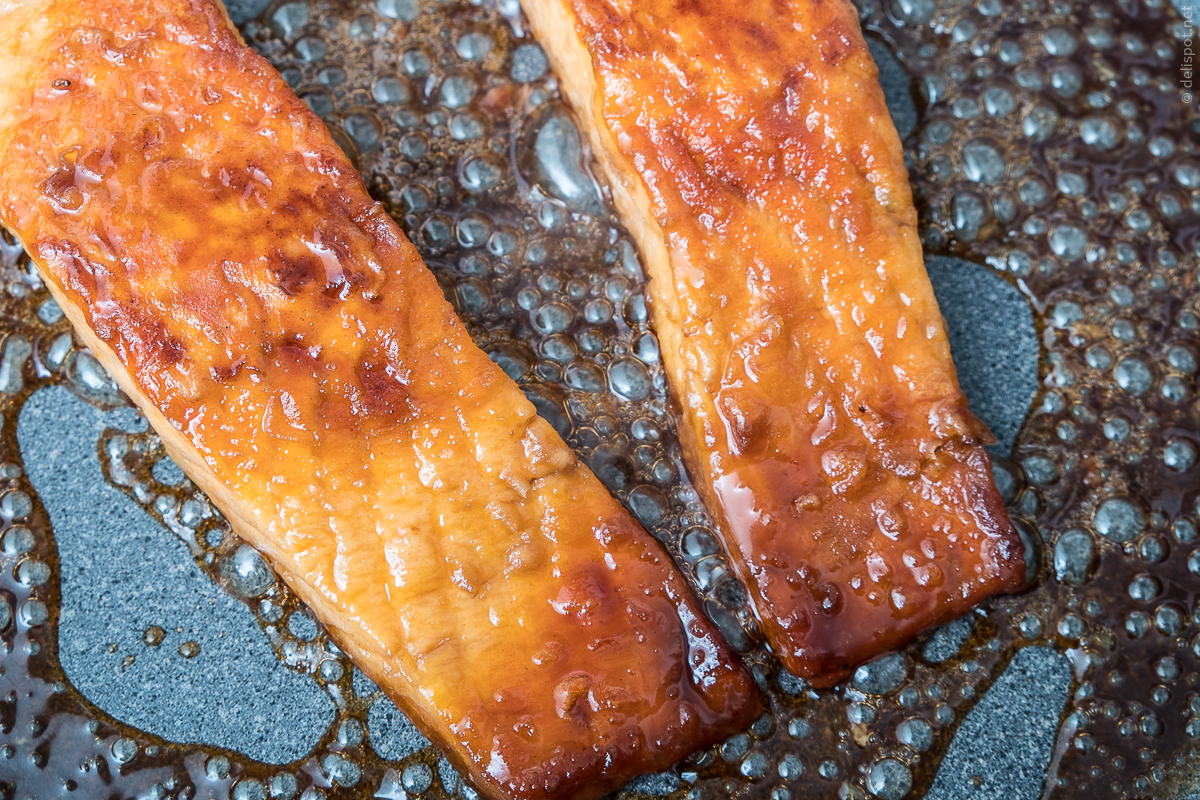 Lachs-Teriaki, kurz vor der Fertigstellung: Zwei Lachsfilets werden mit Teriyaki-Sauce glasiert